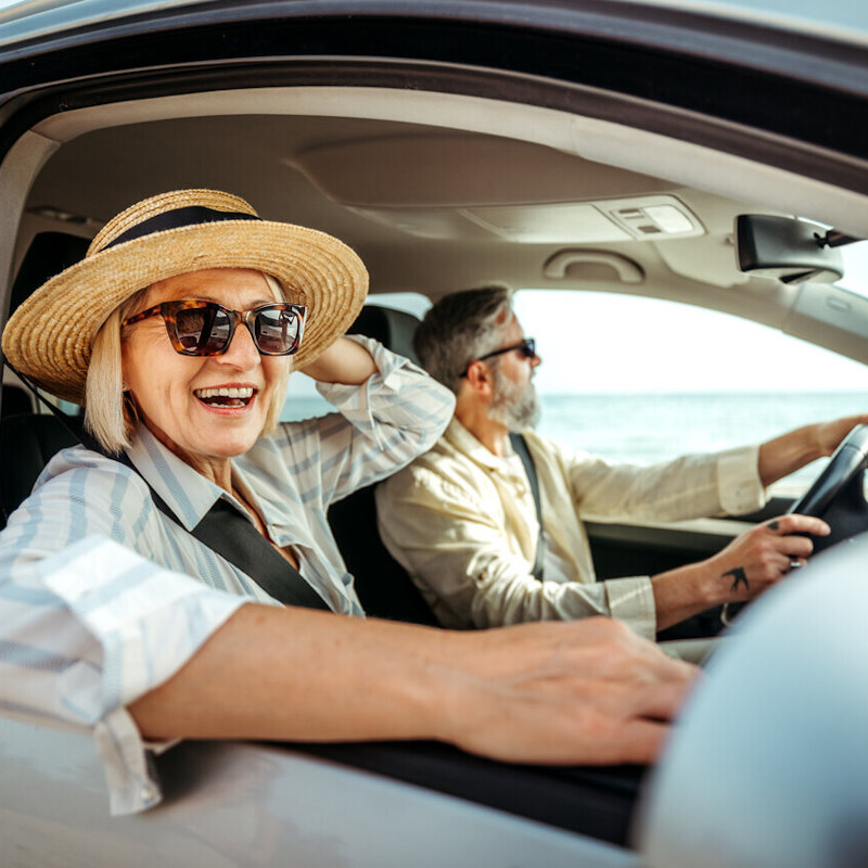 Image of an elderly couple smiling in the car