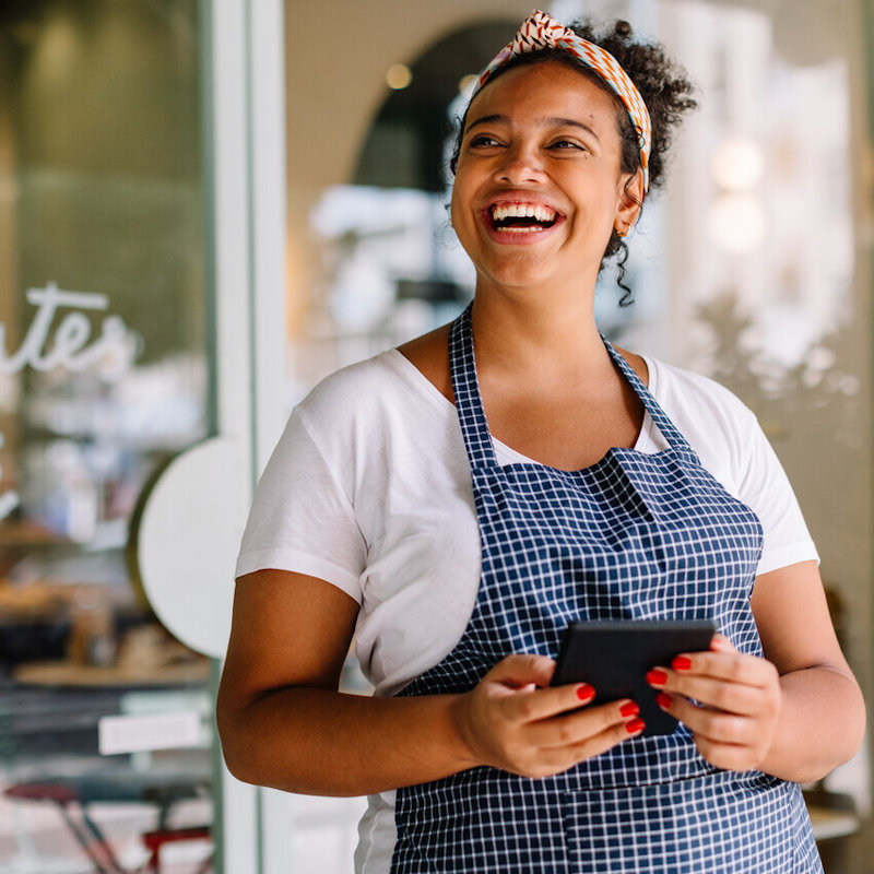 Image of a woman smiling while holding a calculator