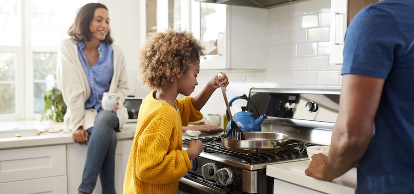 Image of parents teaching their daughter to cook