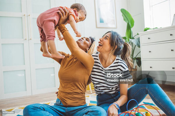 Image of two girls lifting a baby