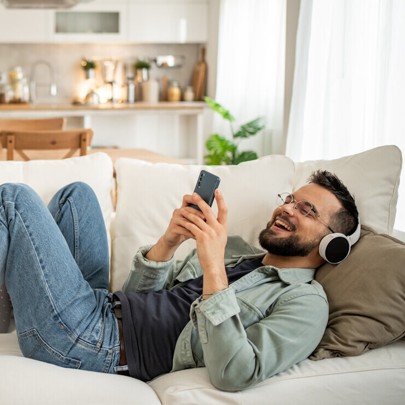 Image of a man lying on the sofa with his phone