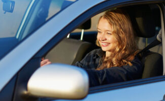 Image of a happy teenager driving a car