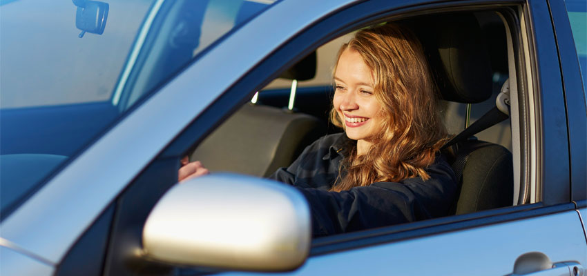 Image of a happy teenager driving a car