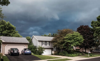 Image of a New England home with a storm brewing above