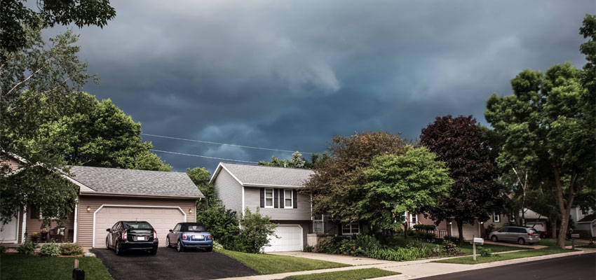Image of a New England home with a storm brewing above