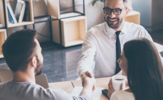 Couple meeting with their insurance agent shaking hands