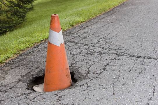 Pothole with safety cone