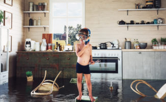 Boy standing in a flooded kitchen