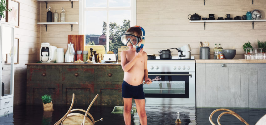 Boy standing in a flooded kitchen