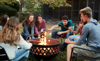 Group of friends making smores by fire pit